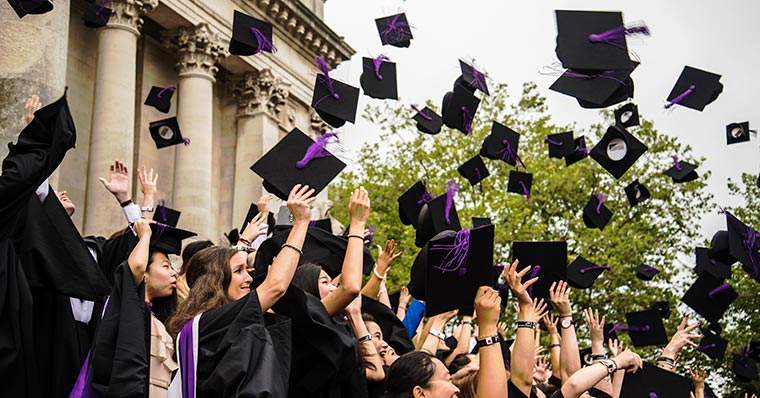 Graduating students throwing caps into the air