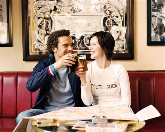 Happy couple cheersing each other in a pub