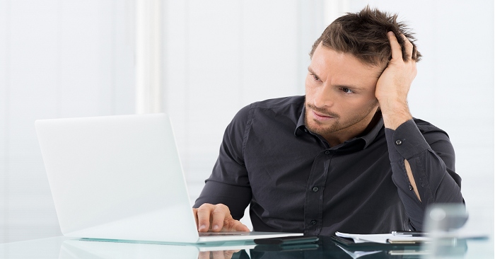 Man sitting at desk looking at computer