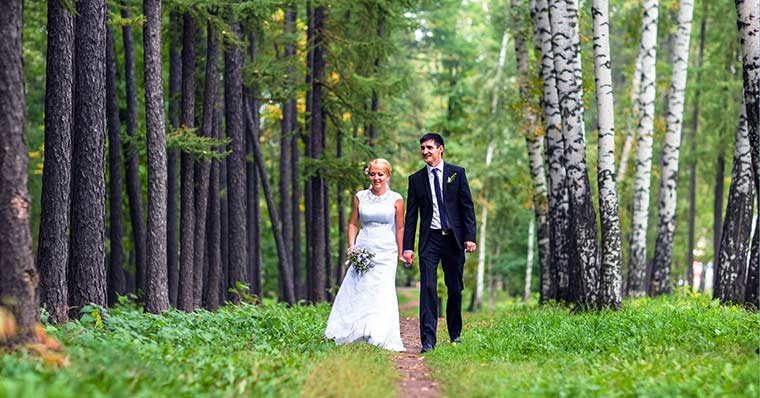 Wedding couple walking through the a forest