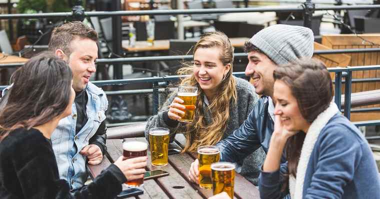 Young friends drinking beer at pub