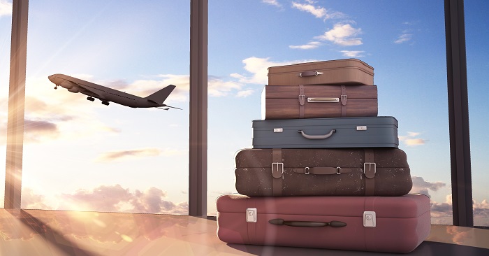 Plane departing airport next to suitcases
